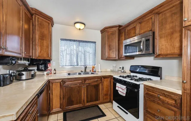 a kitchen with stainless steel appliances a stove a sink a stove cabinets and a microwave