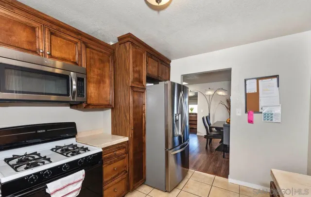 a kitchen with stainless steel appliances granite countertop a refrigerator and a stove top oven