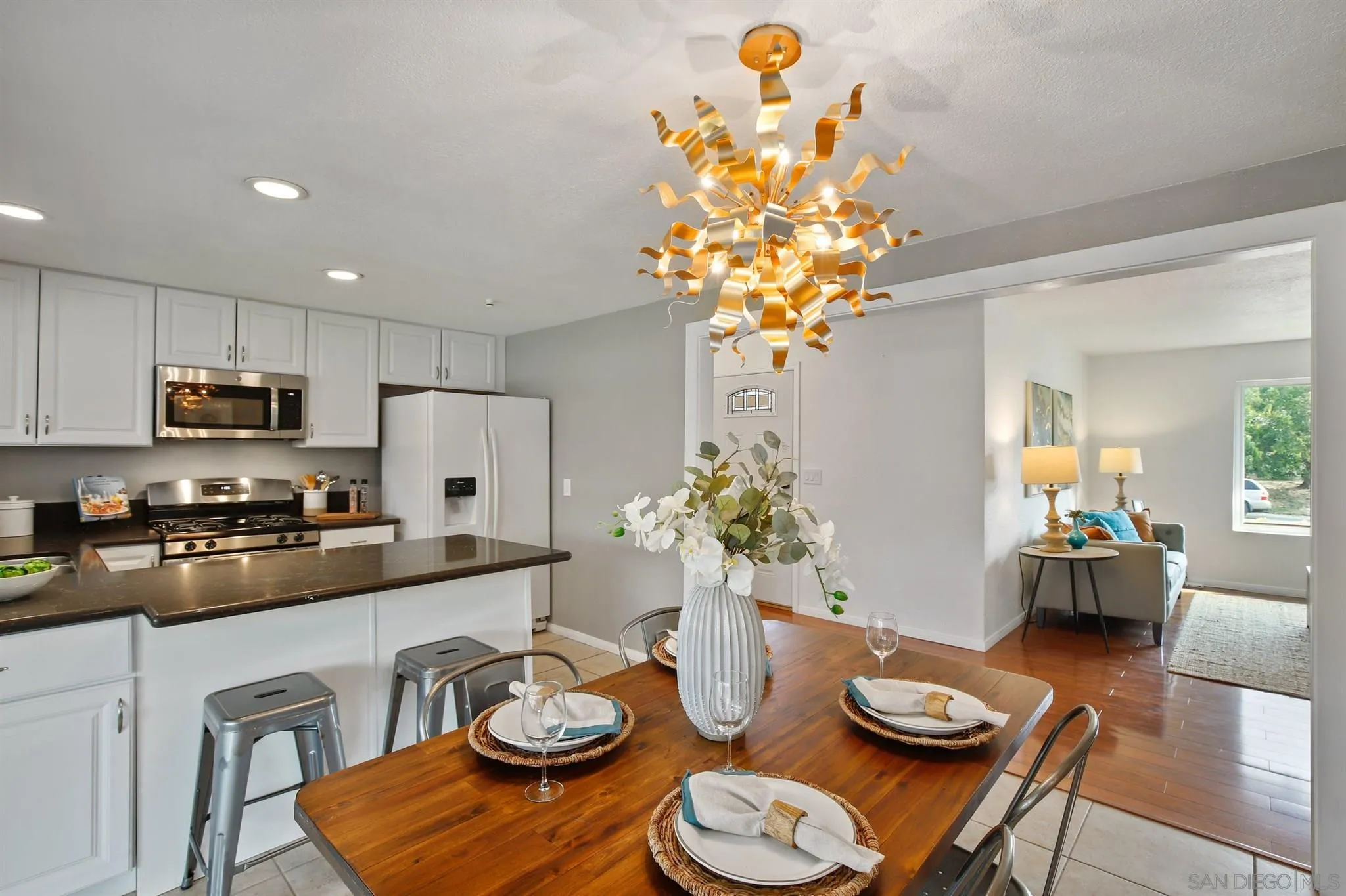 a kitchen with stainless steel appliances granite countertop a dining table and chairs in it
