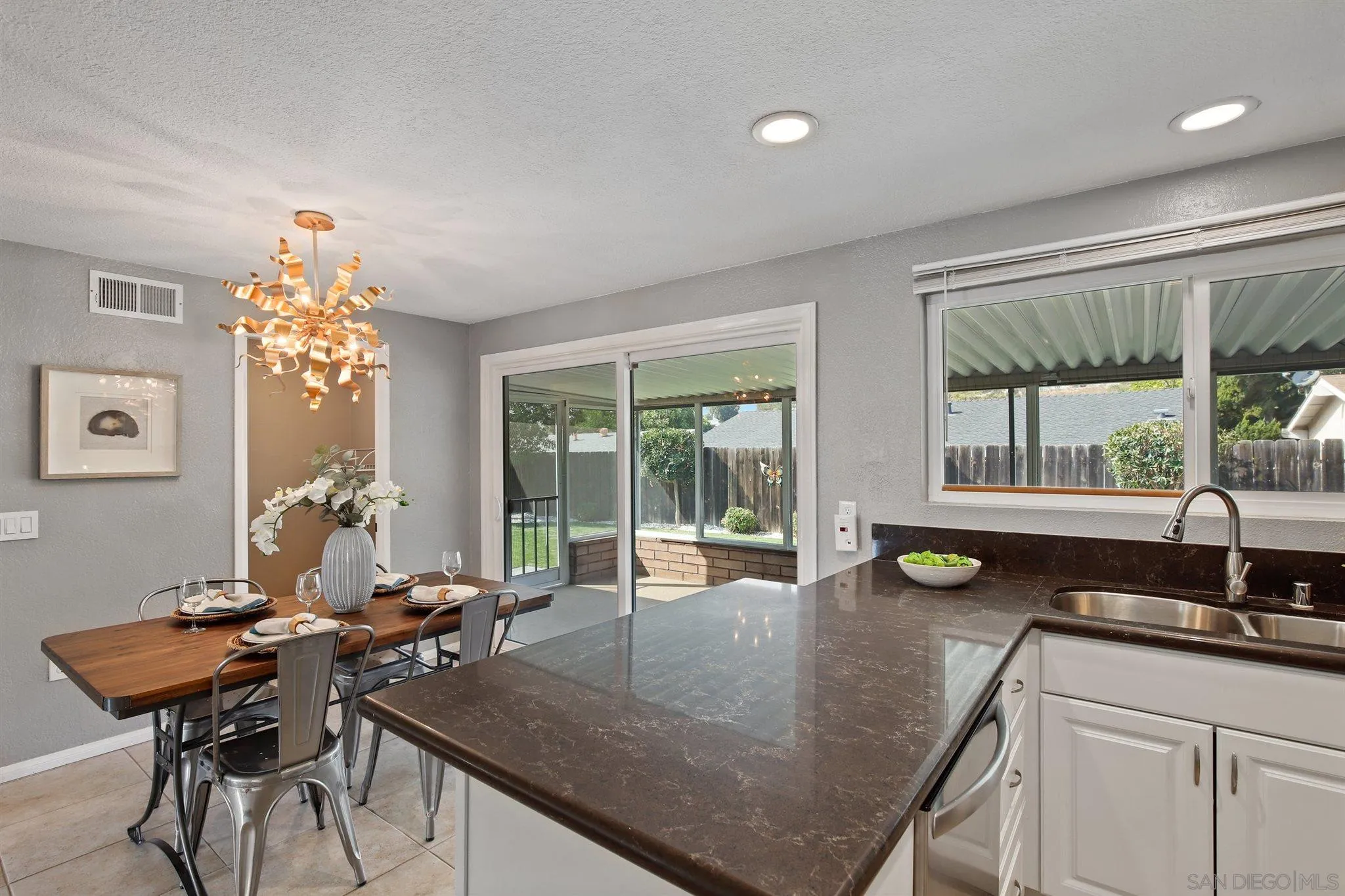 13432 Carriage Road Poway, CA 92064 - Photo 12 of 27 a kitchen with a table chairs and glass door