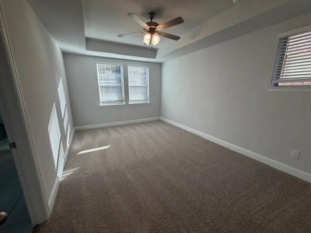 an empty room with windows and fan