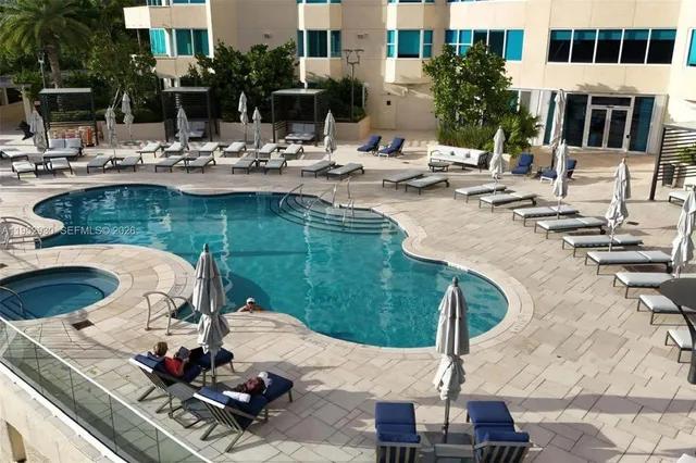 a view of a lake with couches and swimming pool
