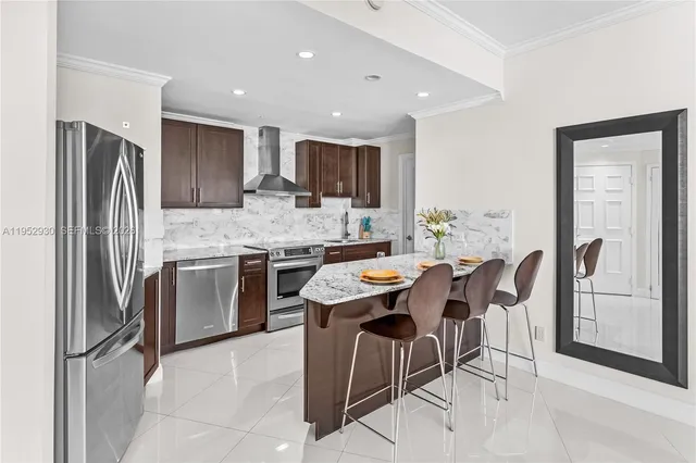 a kitchen with stainless steel appliances kitchen island granite countertop a refrigerator and a stove top oven