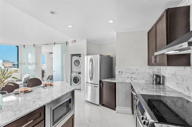 a kitchen with stainless steel appliances granite countertop a refrigerator a stove and a sink