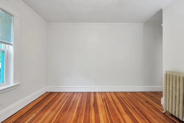 a view of room with window and wooden floor