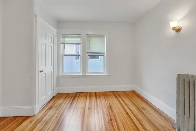 a view of a room with wooden floor and small window