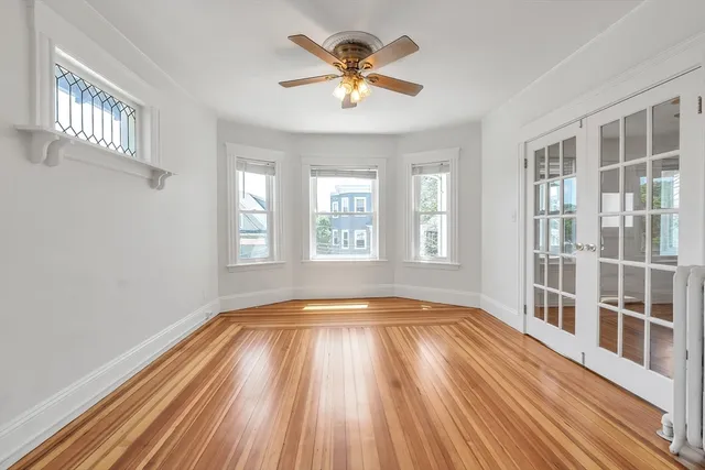 a view of empty room with a window and wooden floor