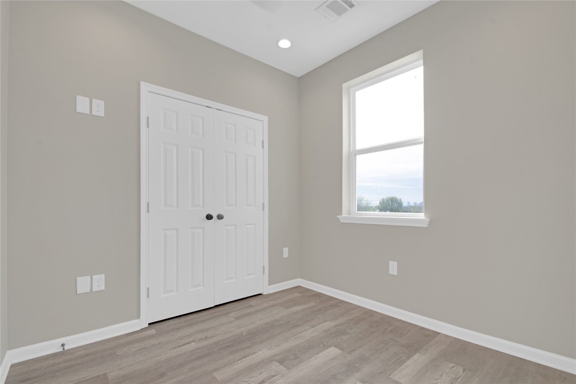 4913 Single Shot Circle, Unit B Austin, TX 78723 - Photo 15 of 21 an empty room with wooden floor and windows