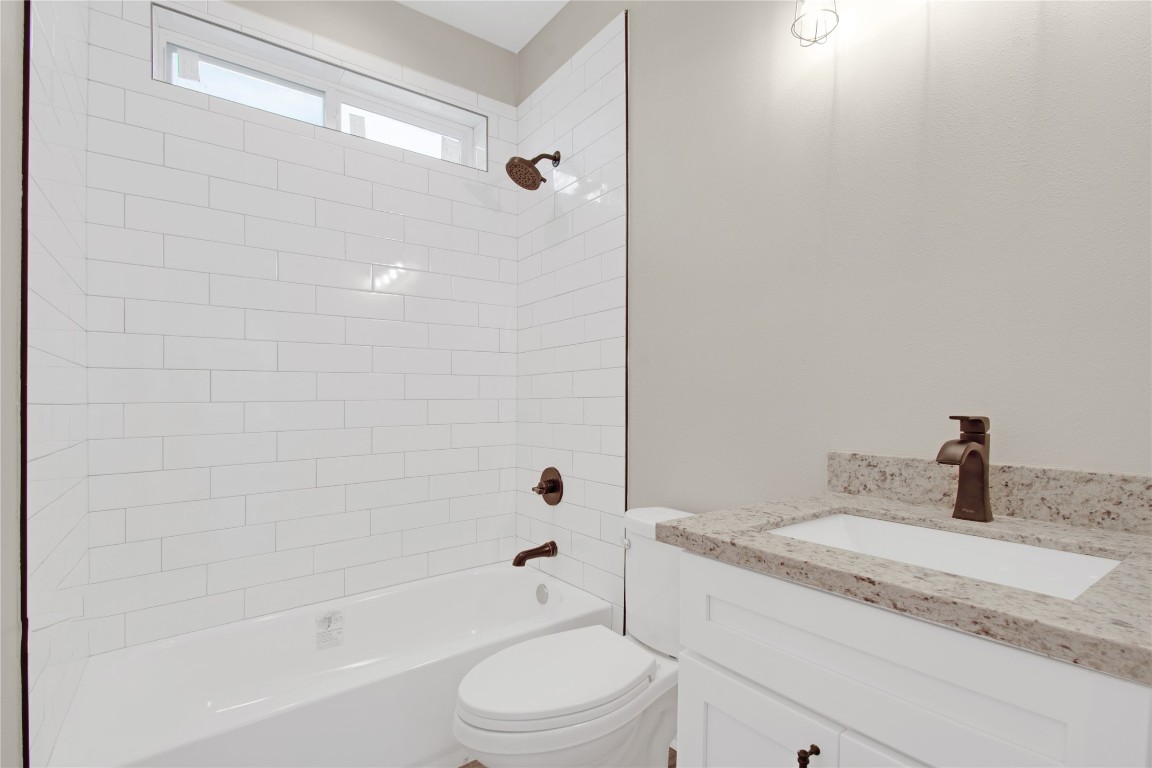 4913 Single Shot Circle, Unit B Austin, TX 78723 - Photo 16 of 21 a bathroom with a granite countertop sink a toilet and shower