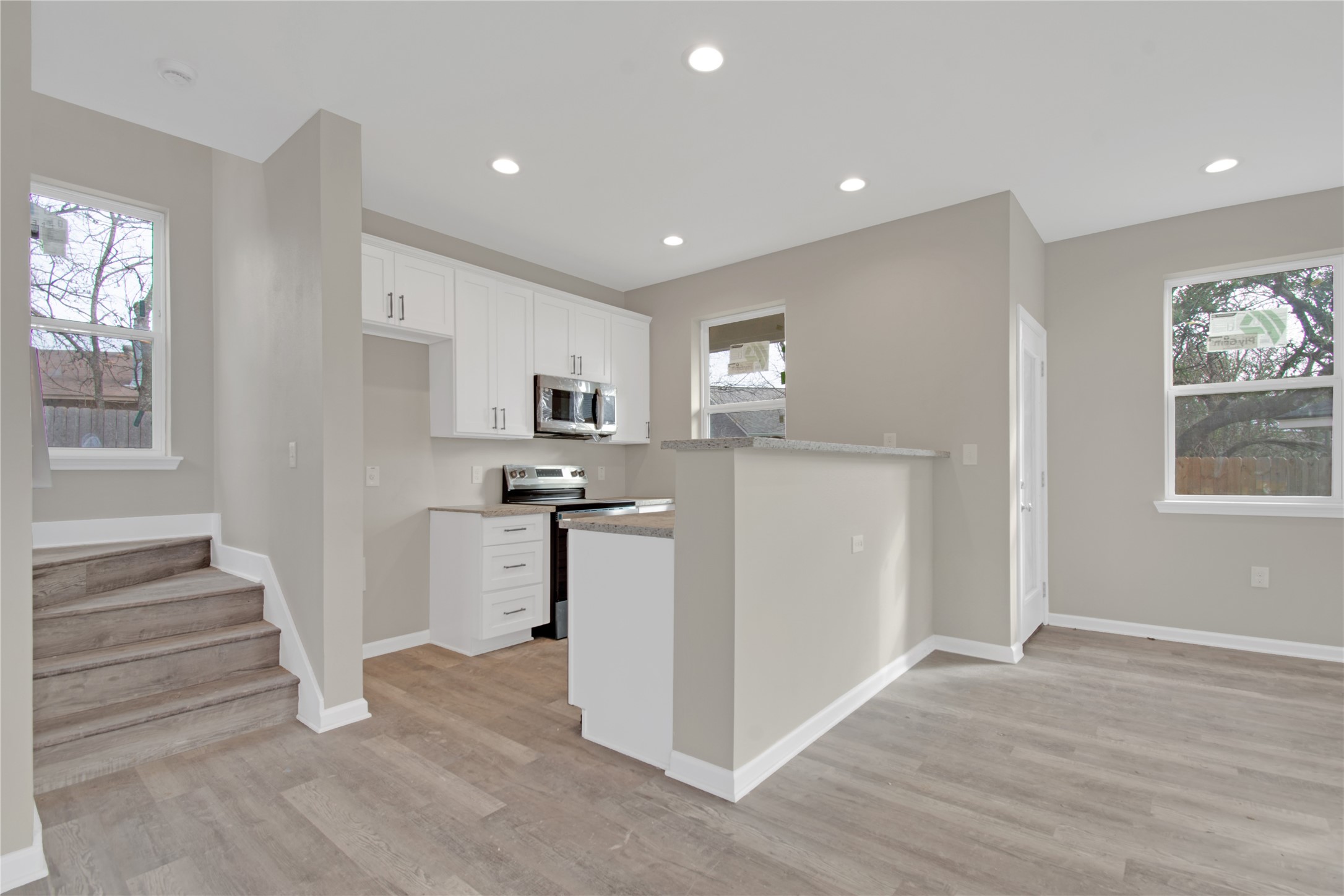 4913 Single Shot Circle, Unit B Austin, TX 78723 - Photo 3 of 21 a kitchen with white cabinets and wooden floor