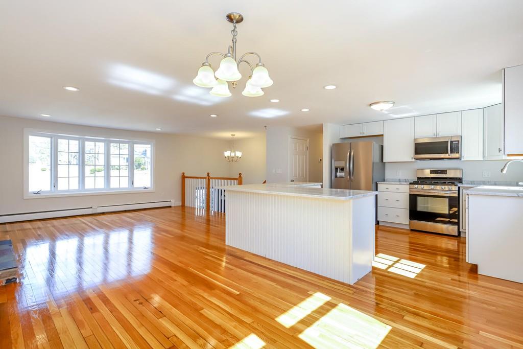 17 Longmeadow Road Medfield, MA 02052 - Photo 4 of 18 a view of a kitchen with kitchen island granite countertop wooden floor stainless steel appliances and a window