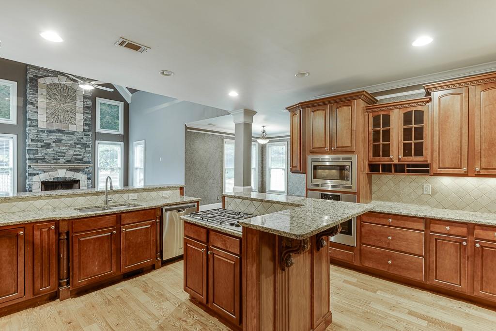 940 Chateau Forest Road Hoschton, GA 30548 - Photo 24 of 87 a dining hall with stainless steel appliances granite countertop wooden cabinets a stove and a granite counter tops with a large window