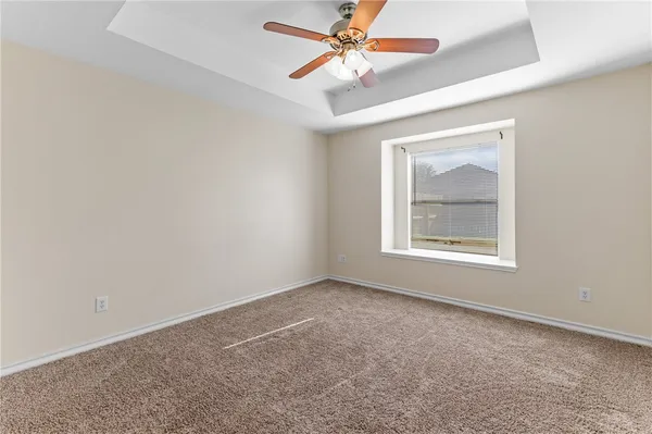 an empty room with a window and a fan