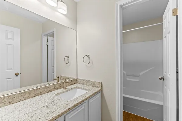 a bathroom with a granite countertop sink and a mirror