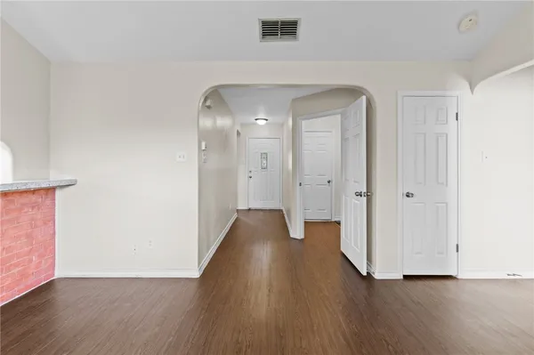 a view of a hallway with wooden floor