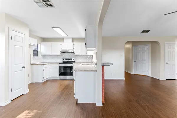 a kitchen with wooden floors and white appliances