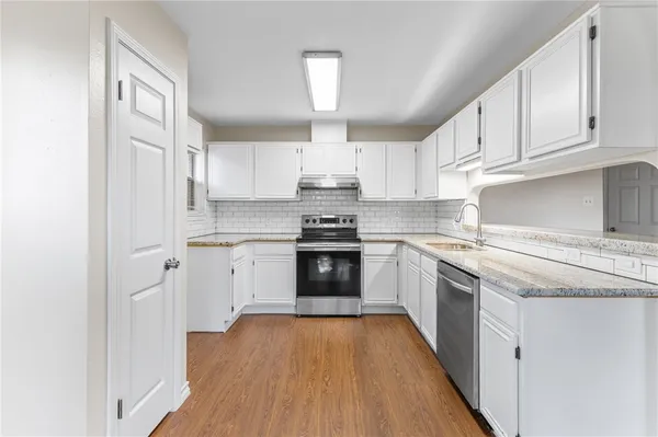a kitchen with granite countertop white cabinets and white appliances