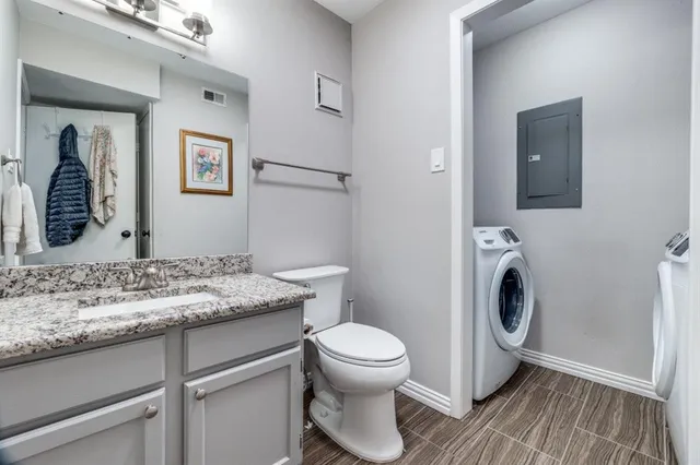 a bathroom with a granite countertop toilet sink and mirror