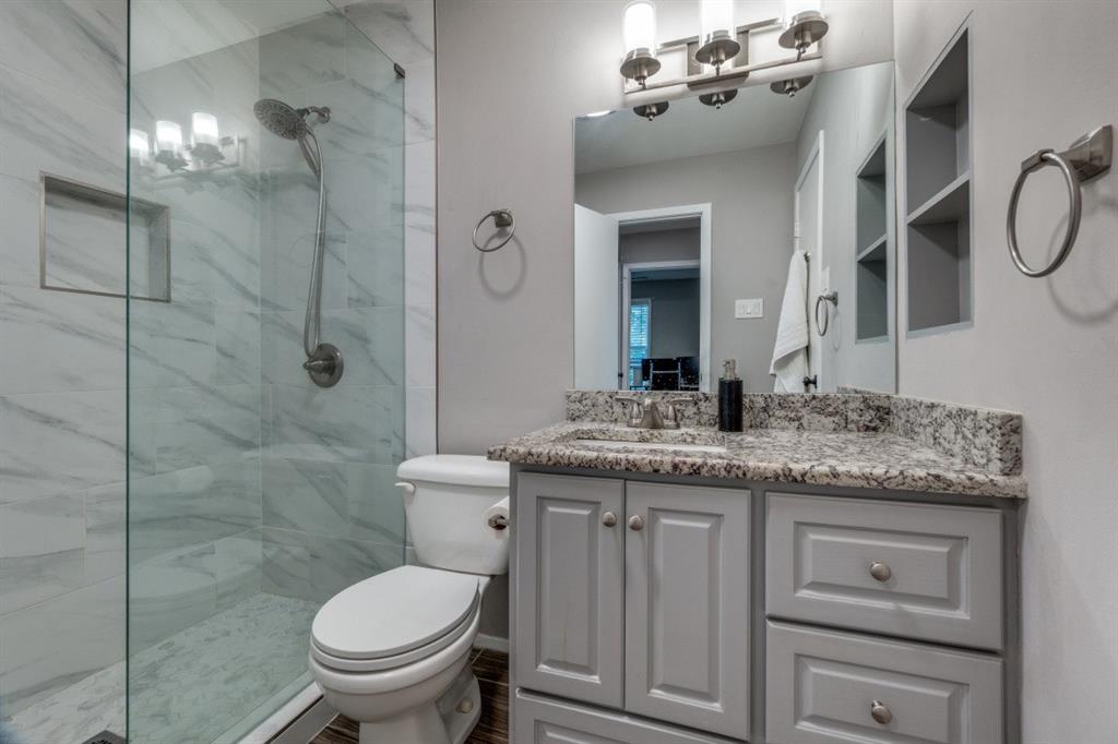 6900 Skillman Street, Unit 109 Dallas, TX 75231 - Photo 17 of 21 a bathroom with a granite countertop sink a toilet and a mirror