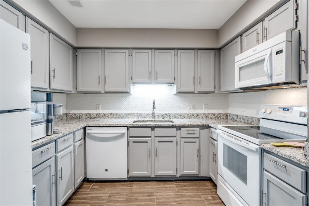 6900 Skillman Street, Unit 109 Dallas, TX 75231 - Photo 7 of 21 a kitchen with stainless steel appliances granite countertop a sink and cabinets with wooden floors
