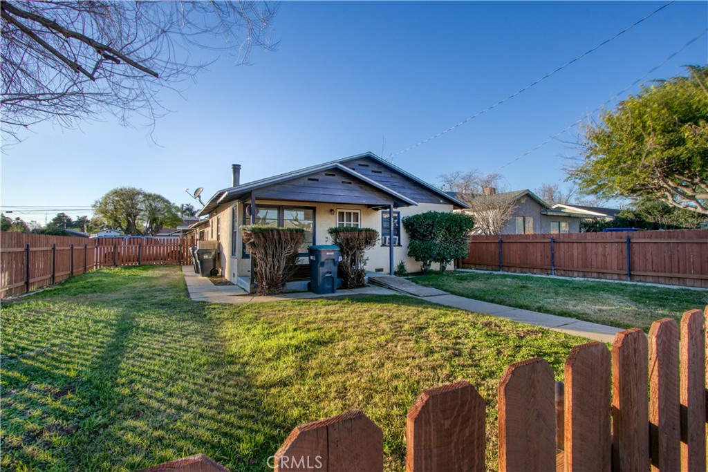 a view of a house with backyard and sitting area