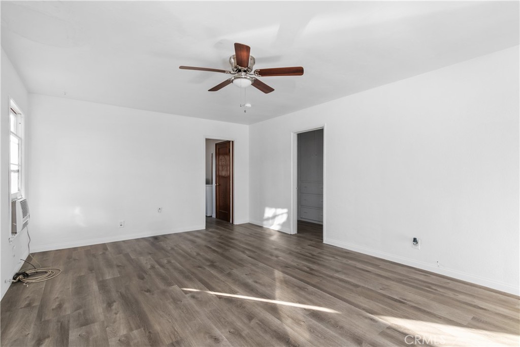 725 Michigan Avenue Beaumont, CA 92223 - Photo 9 of 20 a view of an empty room with wooden floor and a ceiling fan