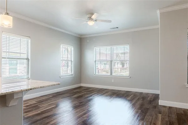 a view of an empty room with a window and wooden floor