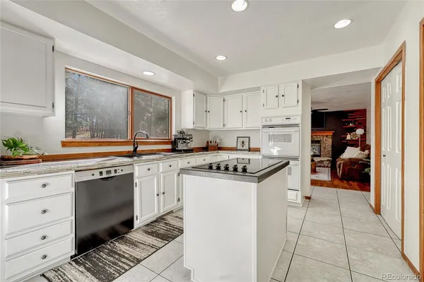 a kitchen with granite countertop a sink stove and cabinets