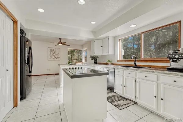 a kitchen with granite countertop a sink and a stove