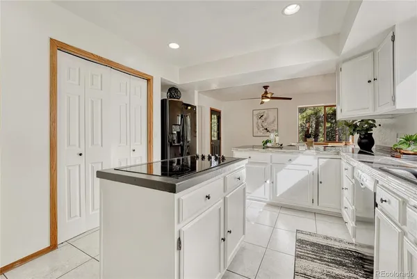 a kitchen with white cabinets and appliances