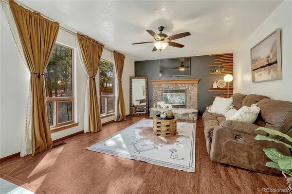 a living room with fireplace furniture and a wooden floor