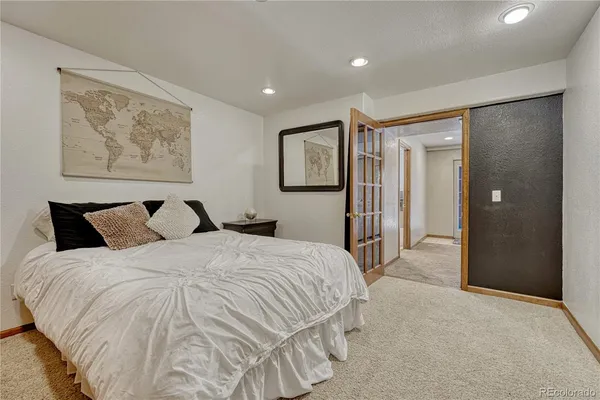 a spacious bedroom with a bed and painting on the wall