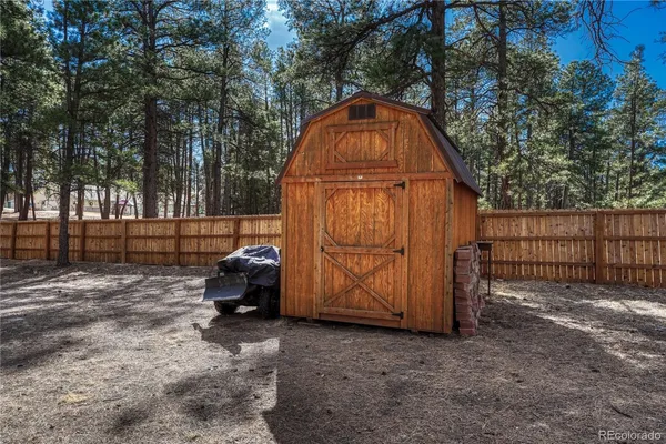 a backyard of a house with barbeque and wooden fence