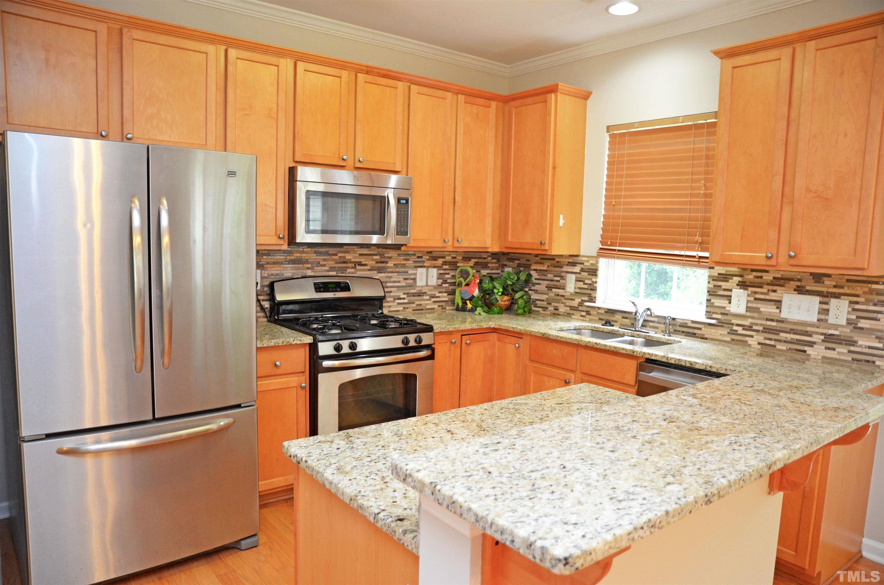 8428 Aztec Dawn Court Raleigh, NC 27613 - Photo 20 of 33 a kitchen with stainless steel appliances granite countertop a refrigerator a stove a sink and a microwave