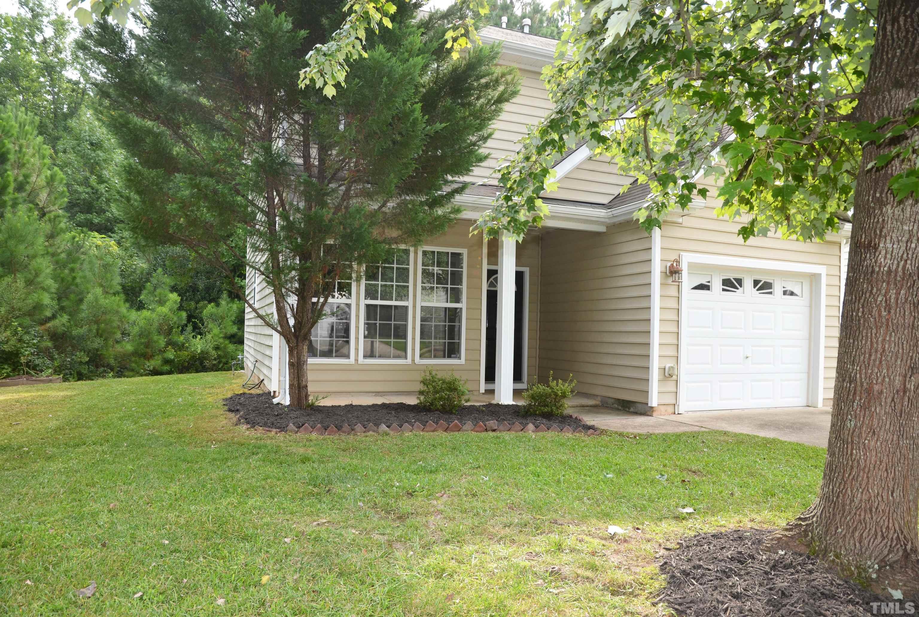 8428 Aztec Dawn Court Raleigh, NC 27613 - Photo 23 of 33 a front view of a house with a garden