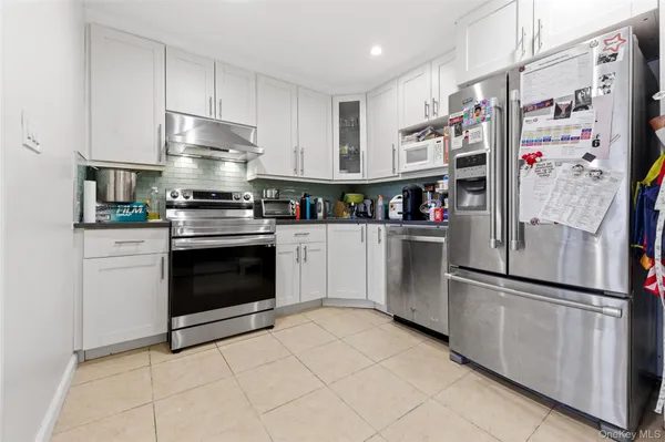 a kitchen with stainless steel appliances a stove top oven and cabinets