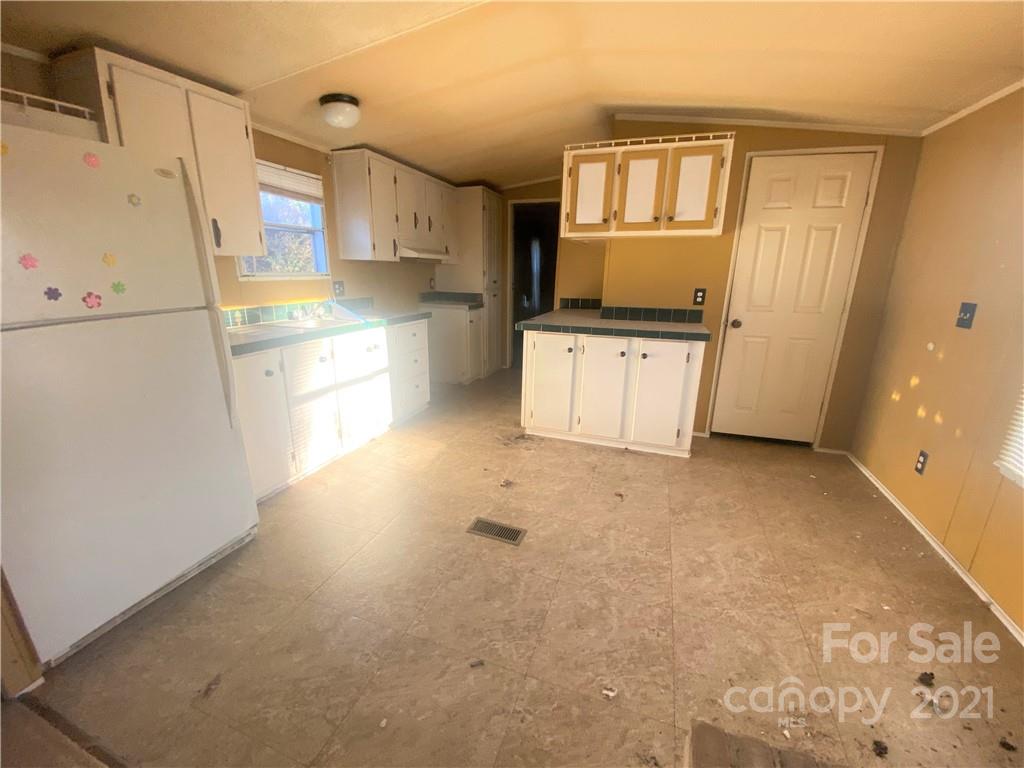 565 Burgray Road Woodleaf, NC 27054 - Photo 5 of 25 a kitchen with granite countertop a refrigerator and a stove top oven