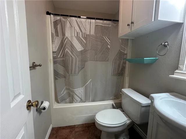 a white toilet sitting next to a bathroom sink and vanity