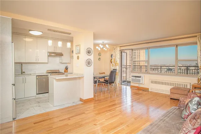 a large white kitchen with wooden floor and a sink