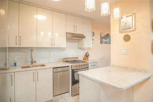 a kitchen with stainless steel appliances white cabinets and a refrigerator
