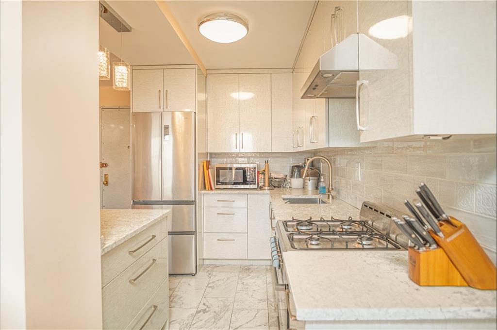 2915-2935 West 5th Street, Unit 13H Brooklyn, NY 11224 - Photo 6 of 16 a kitchen with a stove and a refrigerator