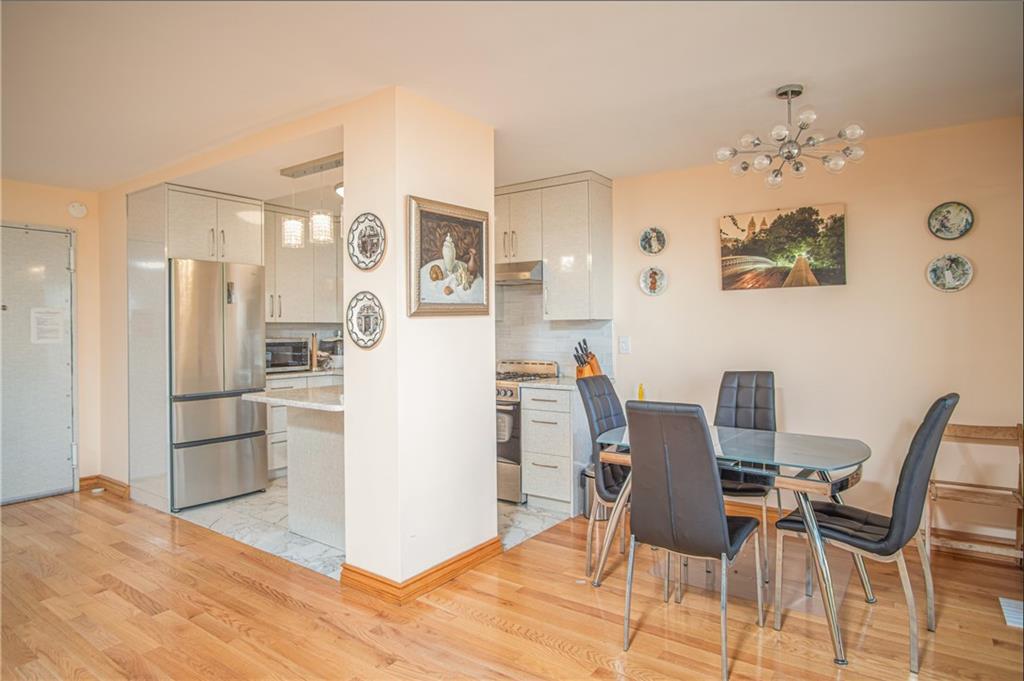 2915-2935 West 5th Street, Unit 13H Brooklyn, NY 11224 - Photo 9 of 16 a view of kitchen with refrigerator and dining table