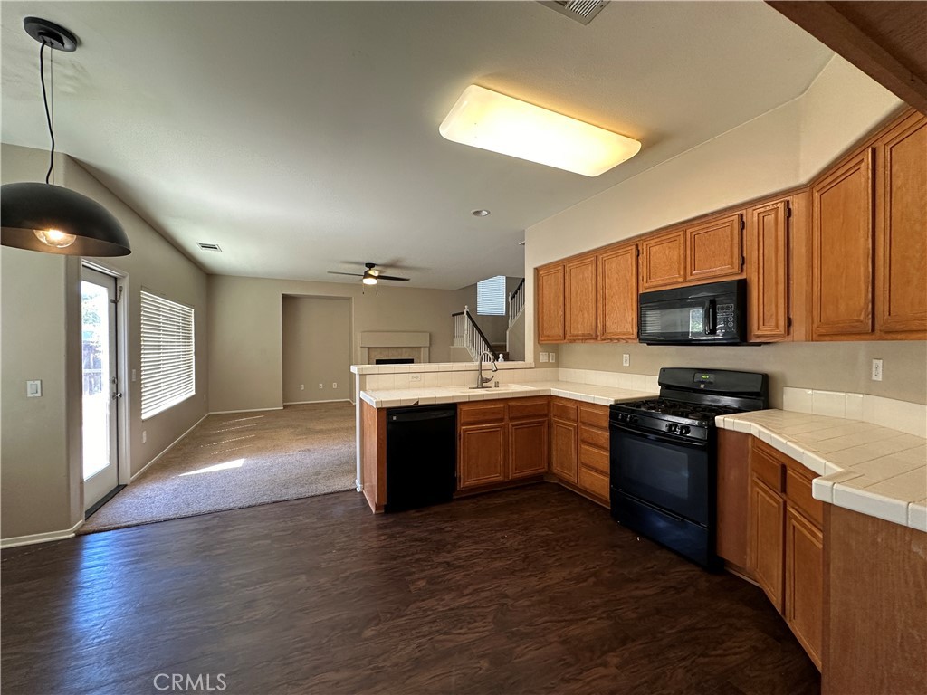 5231 Inglestone Drive Hemet, CA 92545 - Photo 25 of 75 a large kitchen with stainless steel appliances granite countertop a sink dishwasher stove top oven and wooden cabinets