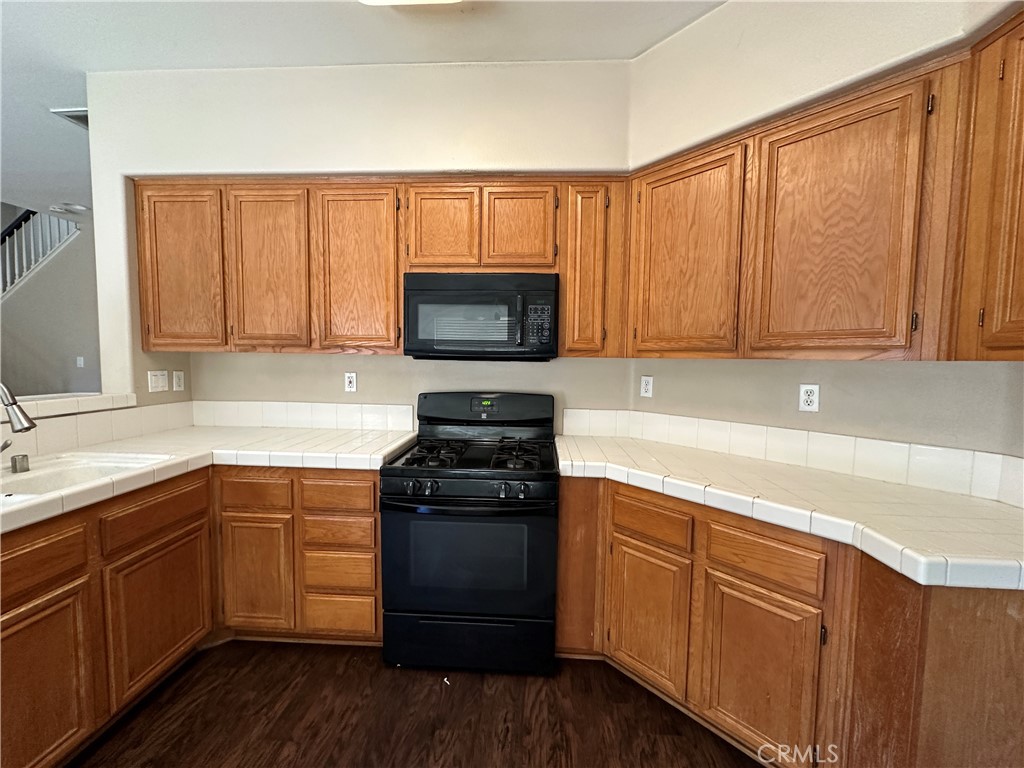 5231 Inglestone Drive Hemet, CA 92545 - Photo 29 of 75 a kitchen with a sink stove top oven and cabinets