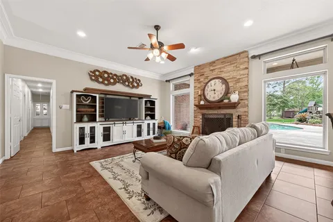 a living room with furniture a fireplace and a large window