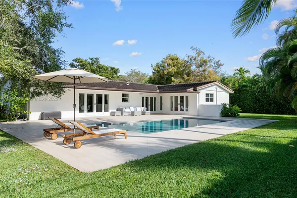 a view of a house with backyard and sitting area