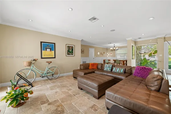 a living room with furniture a rug potted plant and a window