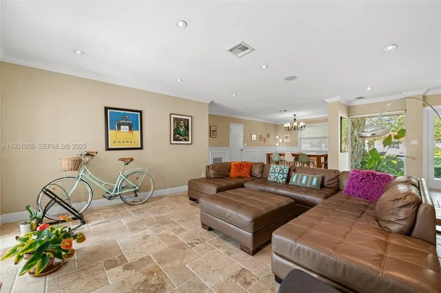 a living room with furniture a rug potted plant and a window