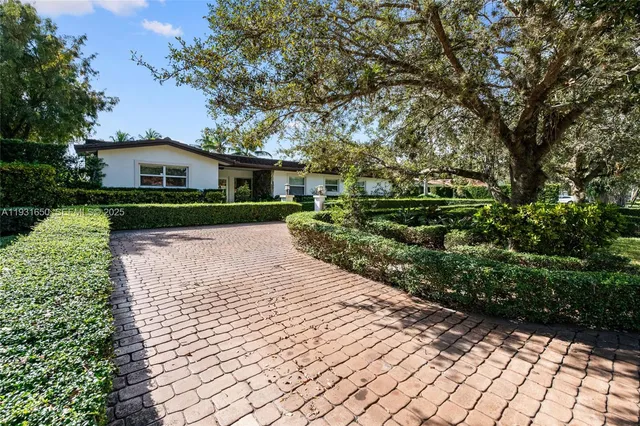 a front view of a house with a yard and trees