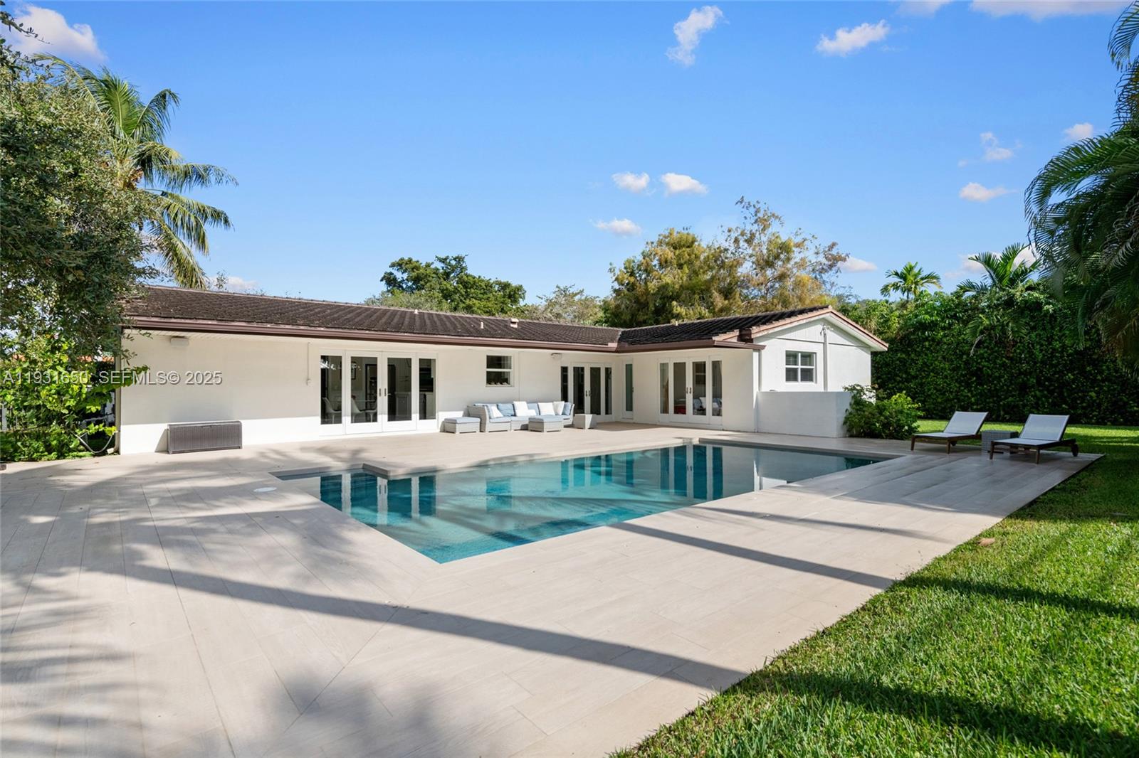 7360 Southwest 115th Street Pinecrest, FL 33156 - Photo 41 of 49 a front view of a house with a garden and yard